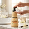 Dłoń naciska pompkę mydła w piance Vione Vanilla Blossom 500 ml przy umywalce